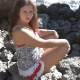 A beautiful, European, brunette girl takes a big, soft shit on a rocky beach. About 2 minutes.